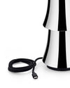 Black and white striped lamp by Alessi with a stacked, flared design and a coiled black braided USB-C cable.