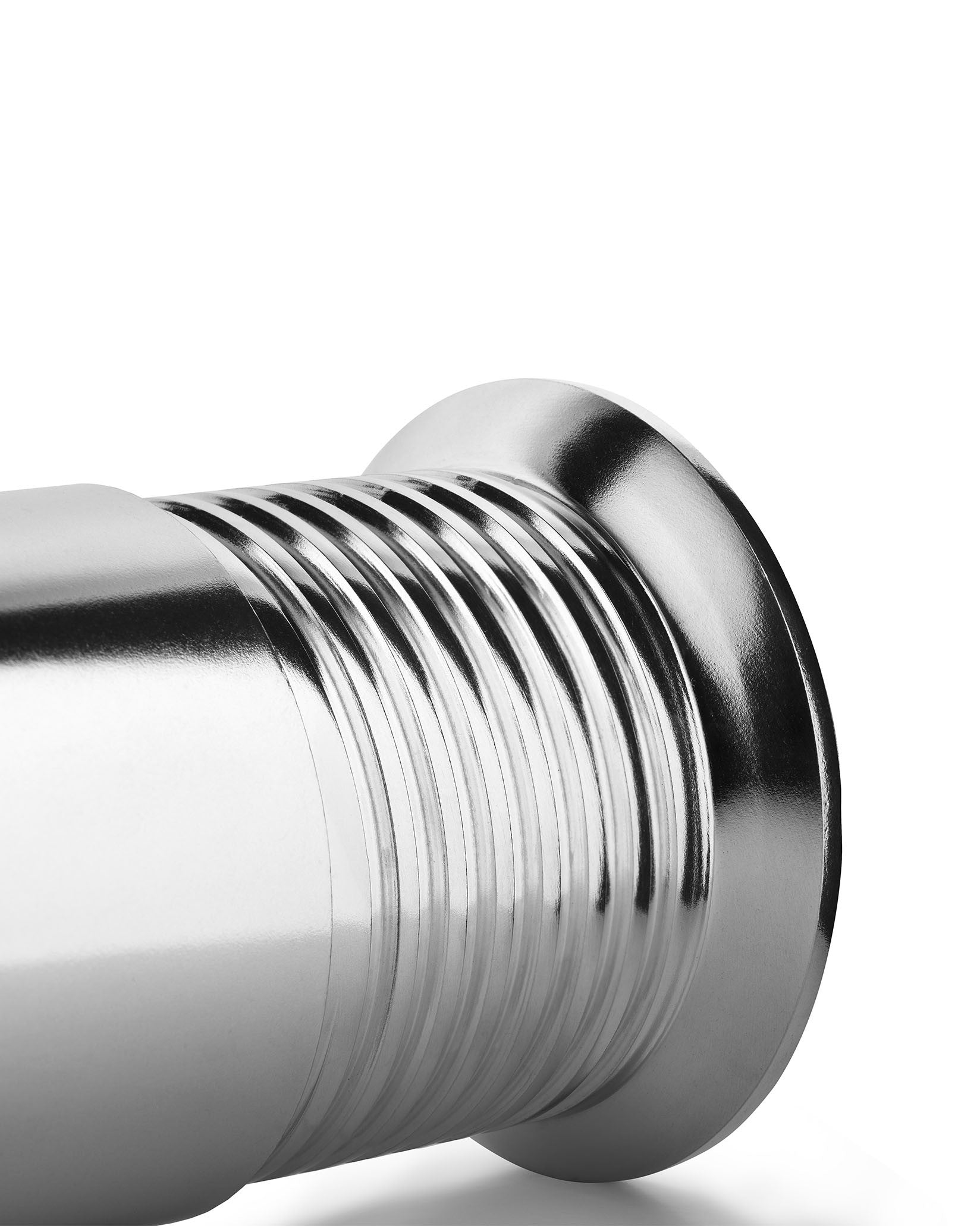 Chrome-plated espresso coffee maker by Alessi with a ribbed, metallic design in a close-up, cropped view.