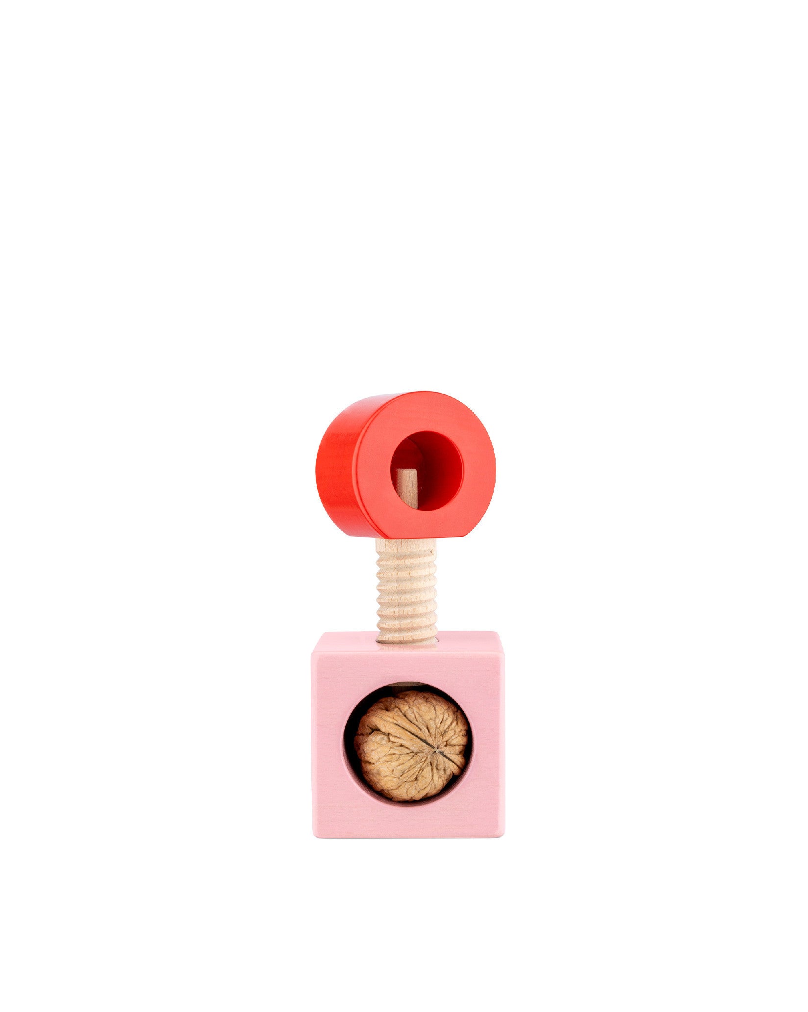 Wooden nutcracker by Alessi with a red ring handle and a pink cube base holding a walnut.