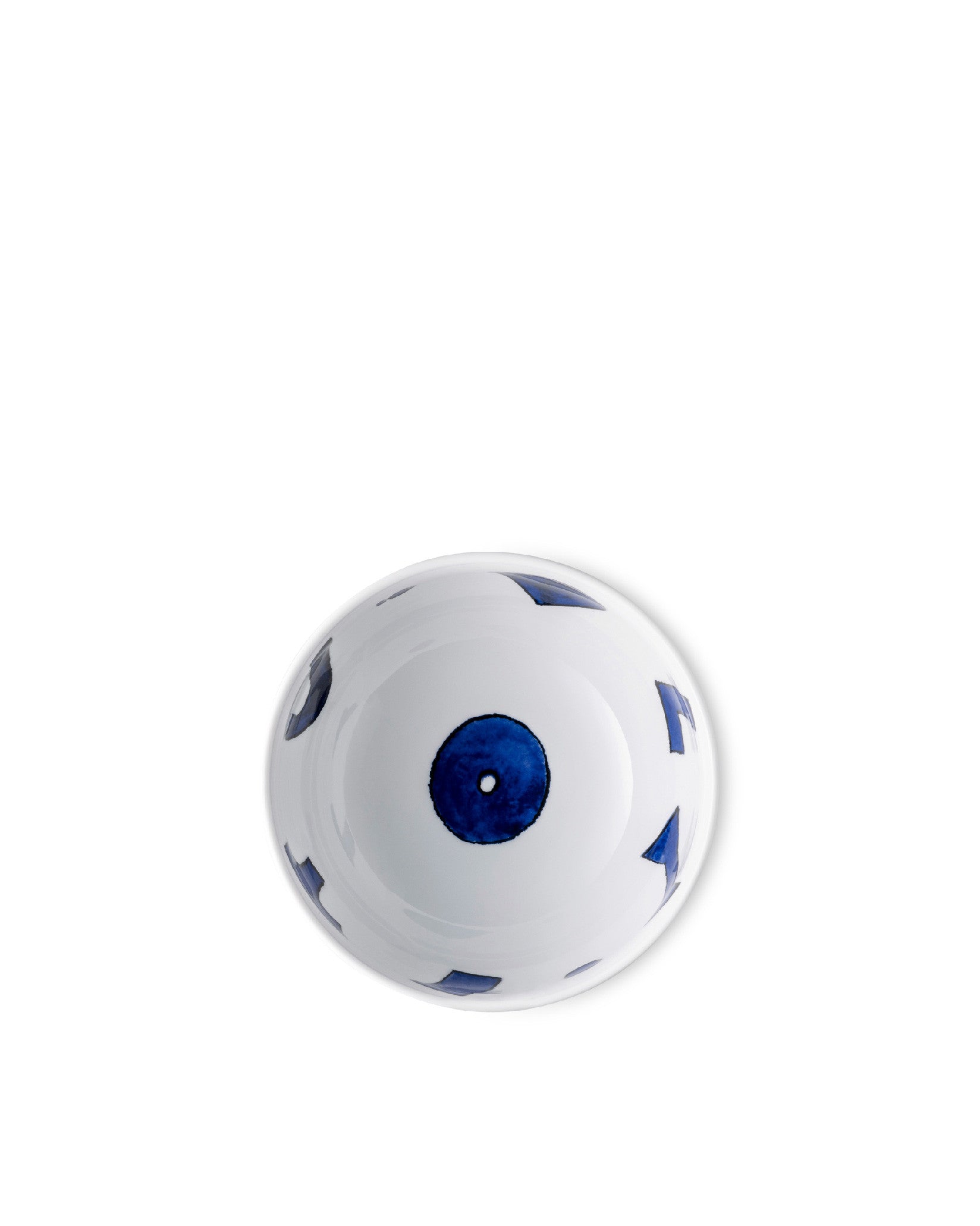 White ceramic bowl by Alessi with a central dark blue circle containing a white dot, and scattered abstract dark blue shapes, viewed from above.