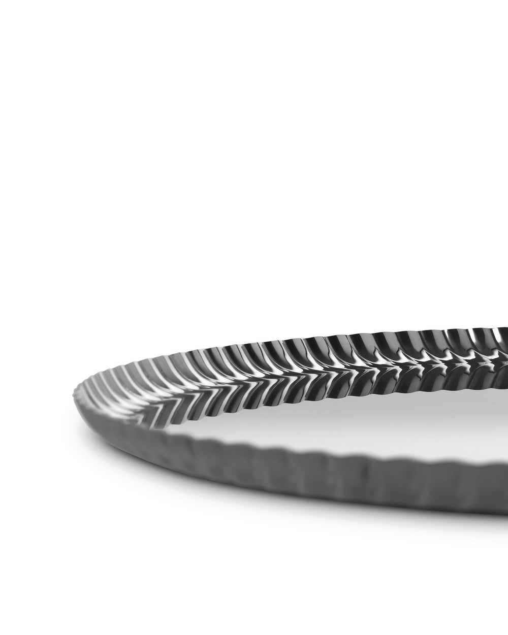 Dark grey metallic tray by Alessi with a distinctive pleated wavy rim, shown from a low angle.