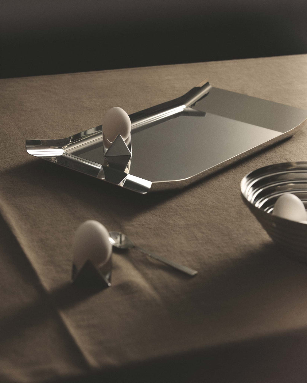 Sleek silver Arran tray by Alessi with rounded corners, styled with eggs in geometric cups.