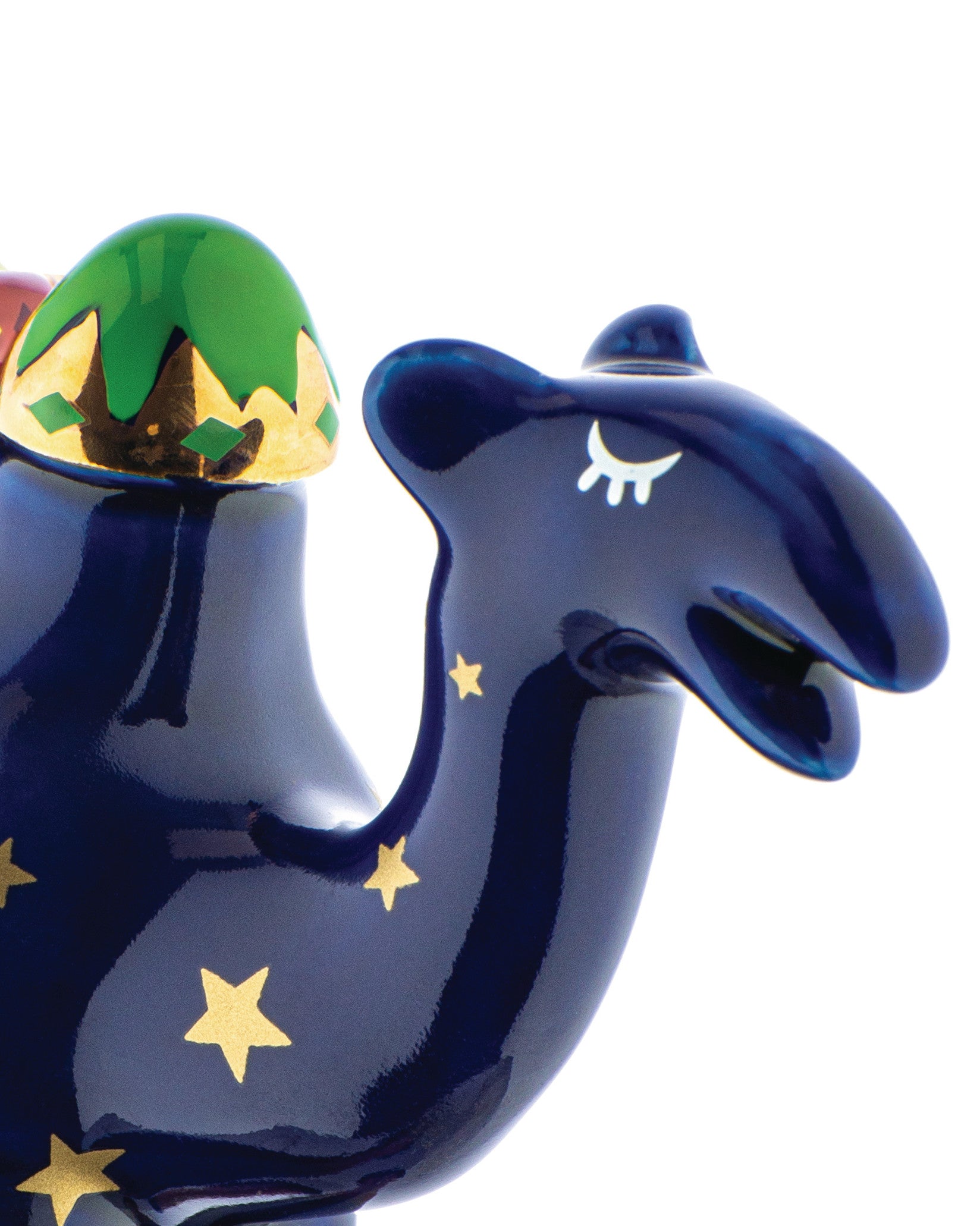 Glossy blue nativity camel figure by Alessi with gold stars, a green and gold patterned hump, and a stylized closed eye.