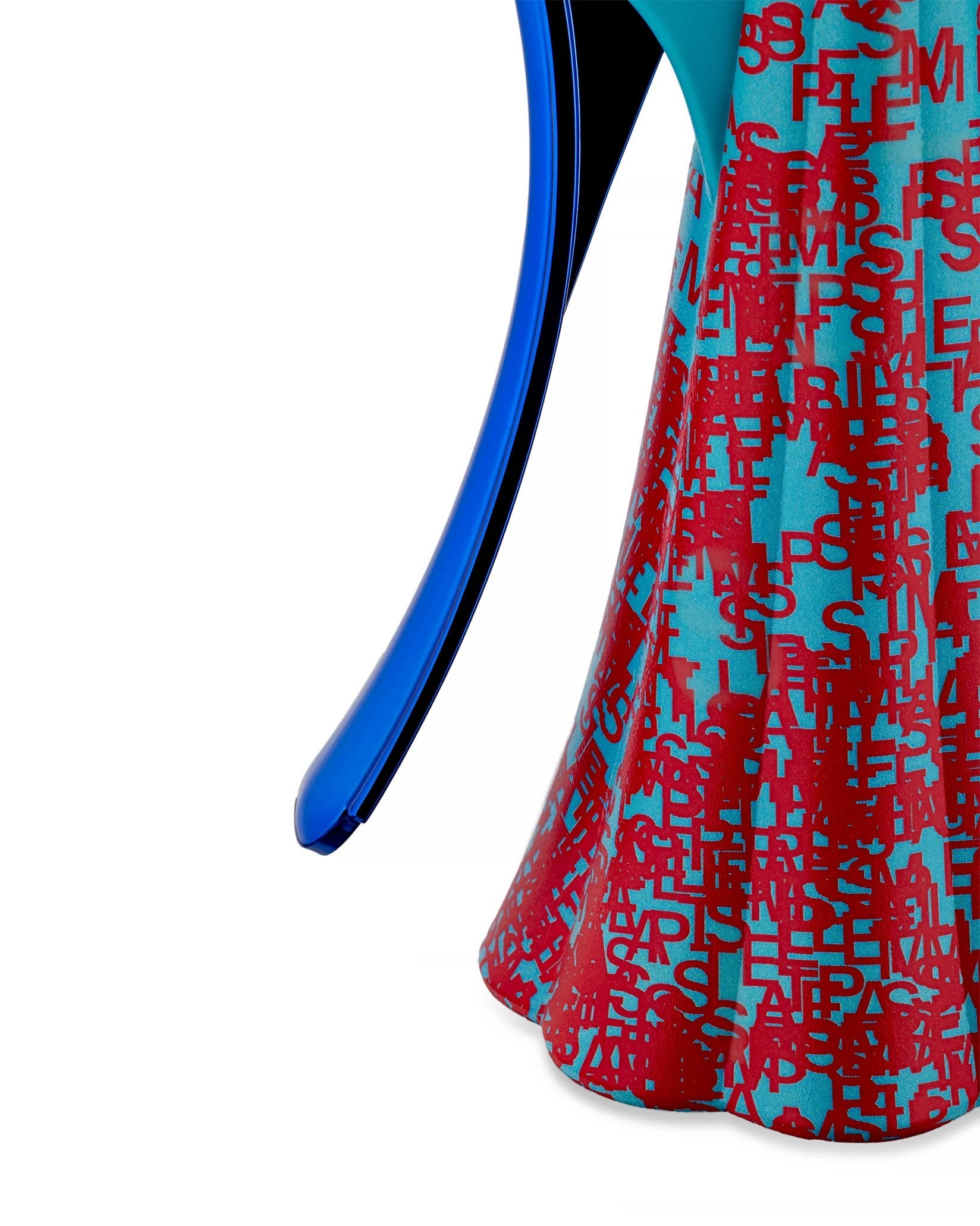 Blue and red letter-patterned corkscrew by Alessi, with a blue lever and scalloped base, cropped side view.