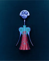 Anna G. figurative corkscrew by Alessi, with a silver smiling face, teal body, and red patterned skirt.