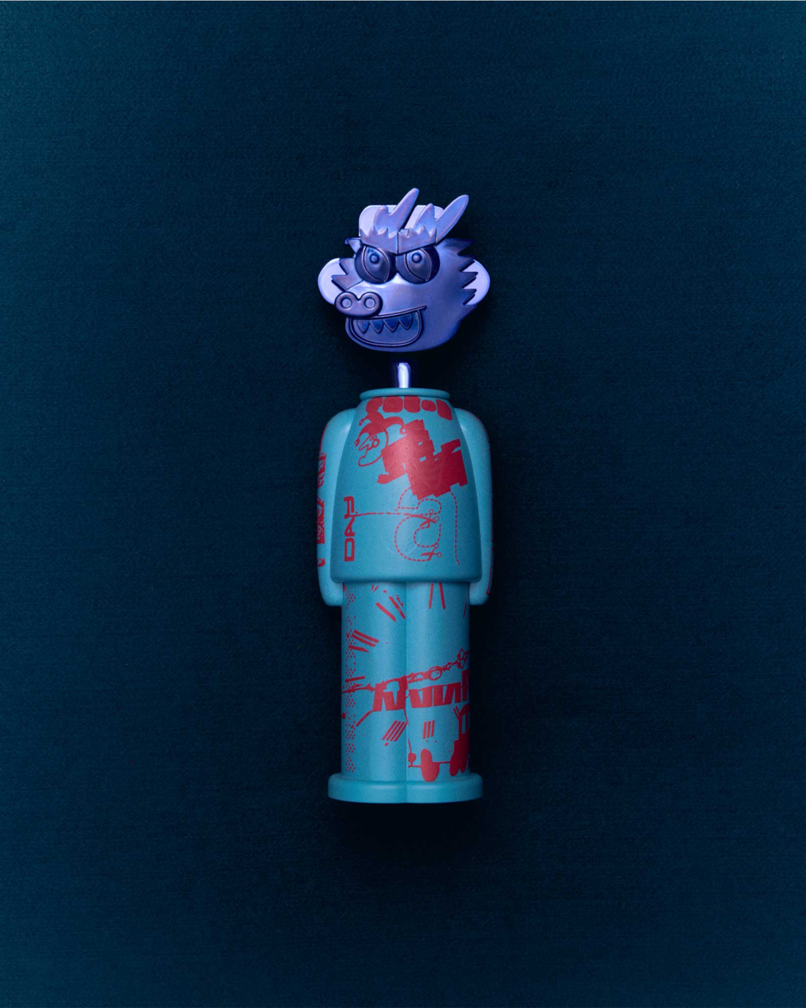 A turquoise figure corkscrew with red patterns by Alessi, featuring a detachable silver dragon head.