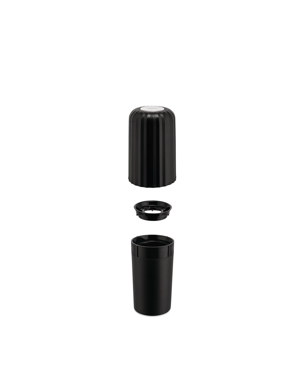 Black plastic capsule crusher by Alessi disassembled into three ribbed pieces.