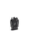 Black metal napkin holder by Alessi with an abstract wavy design on a white background.