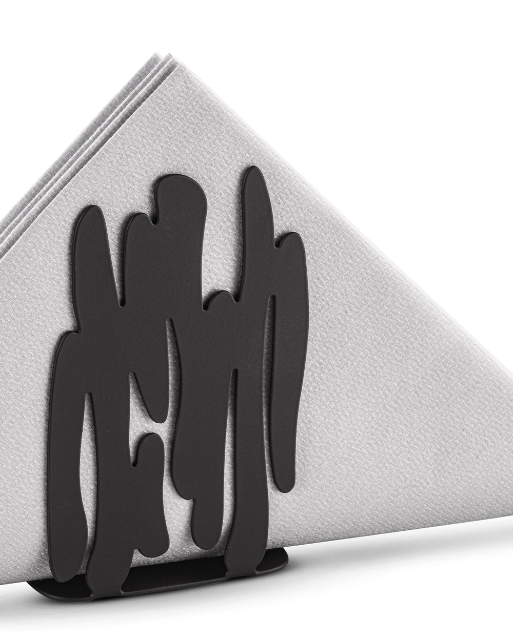 Black metal napkin holder by Alessi with an organic, flowing cut-out design, holding white folded napkins.