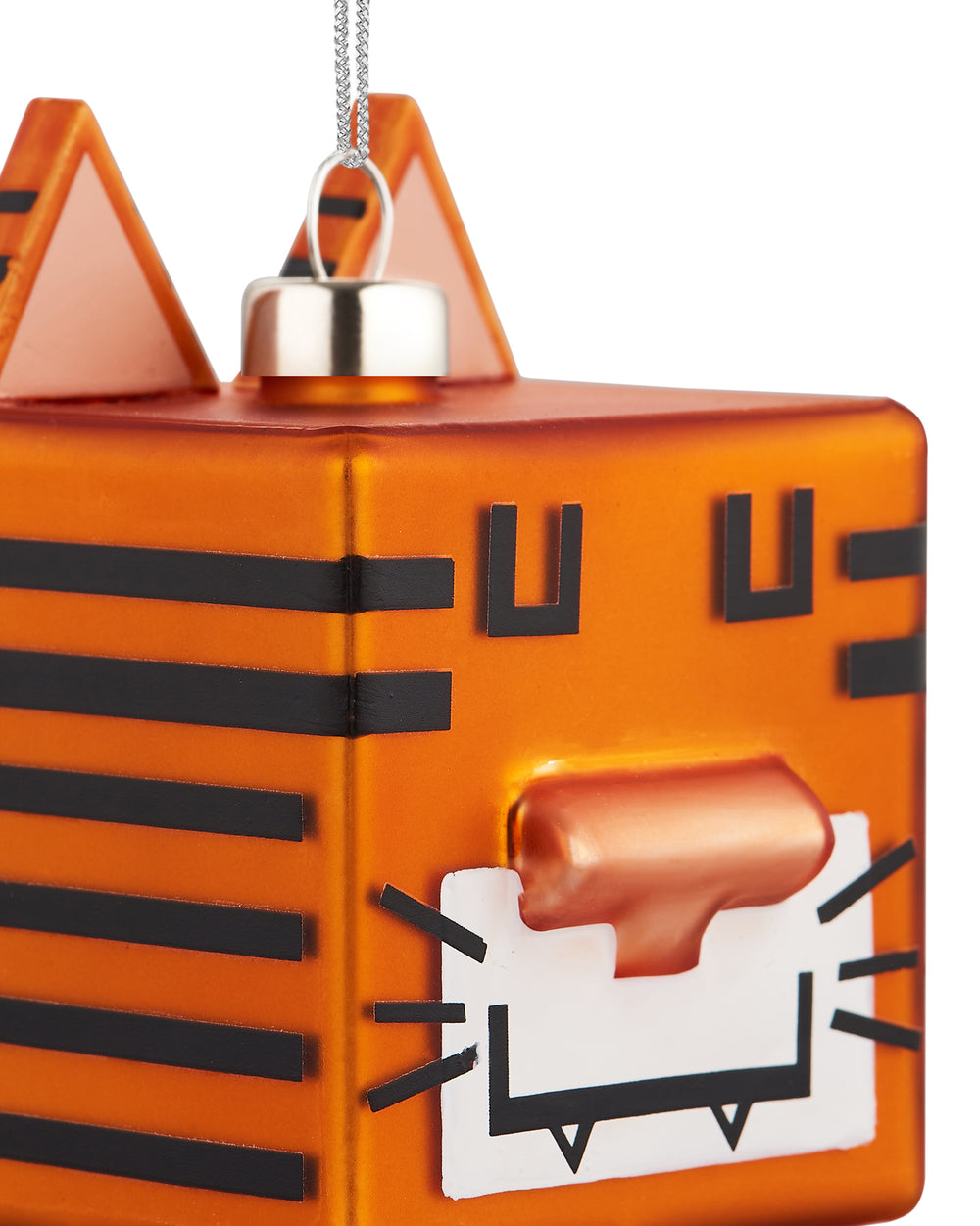An orange, blocky tiger Christmas tree ornament by Alessi, featuring black stripes, angular ears, and geometric facial features.