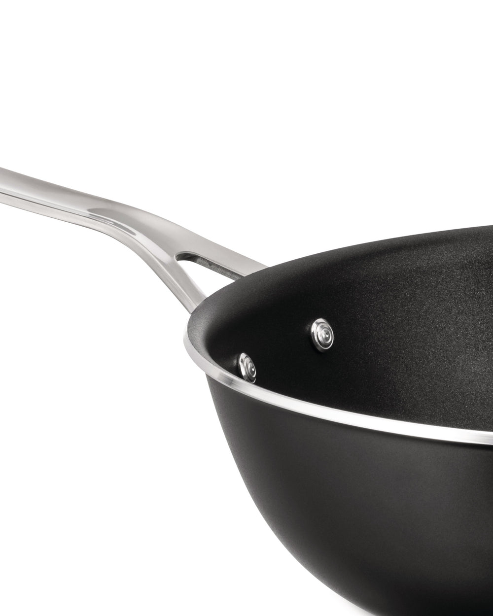 Black non-stick wok pan by Alessi with a silver handle, textured interior, and silver rim, in an angled close-up view.