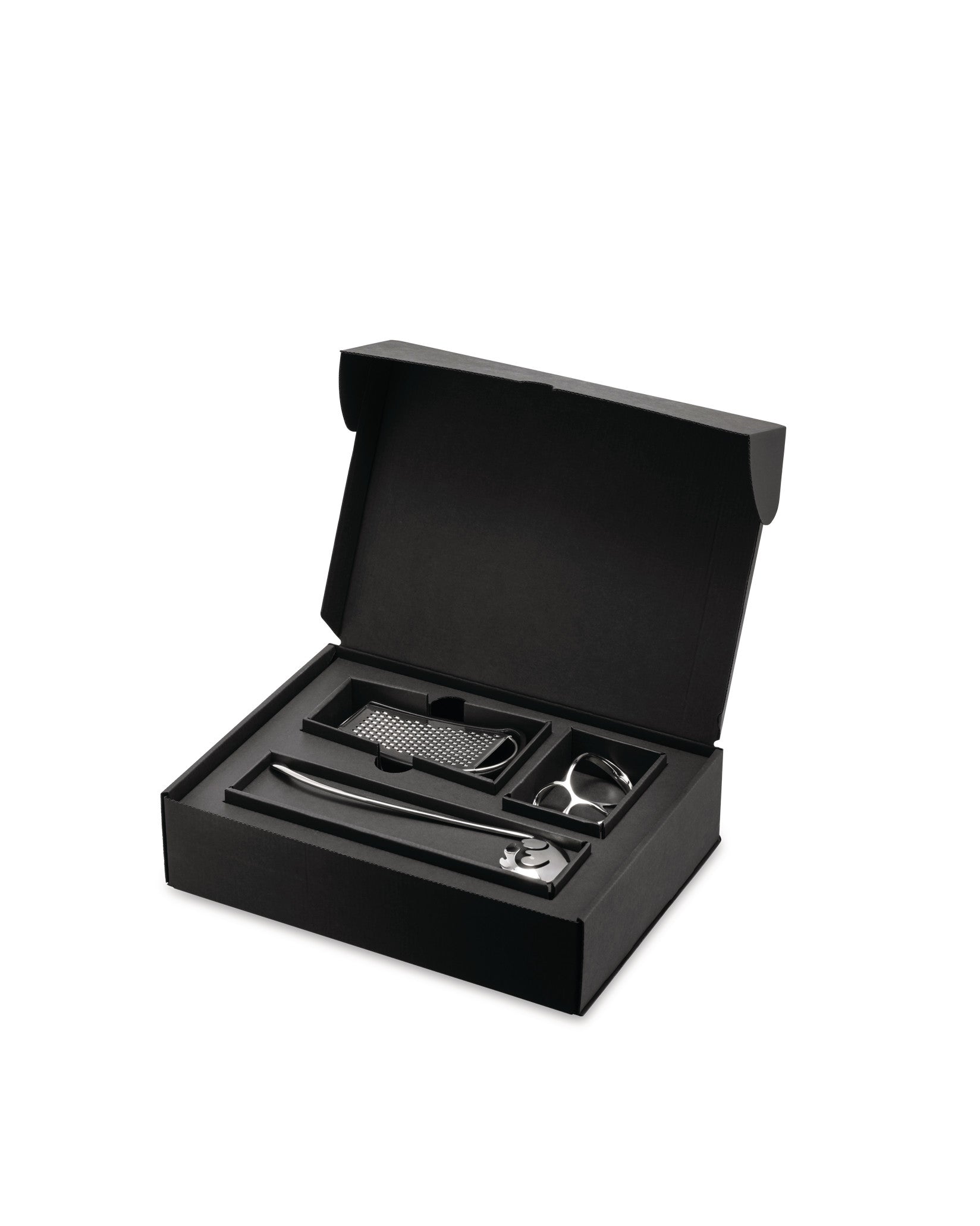 Black pasta gift set by Alessi, open with silver tools: a long spoon, grater, and pasta measure.