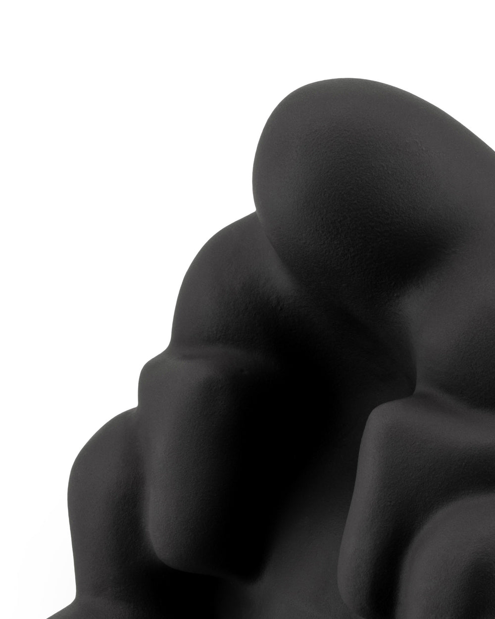Black, matte textured Dédé doorstop by Alessi, showing abstract, organic curved forms in a close-up.