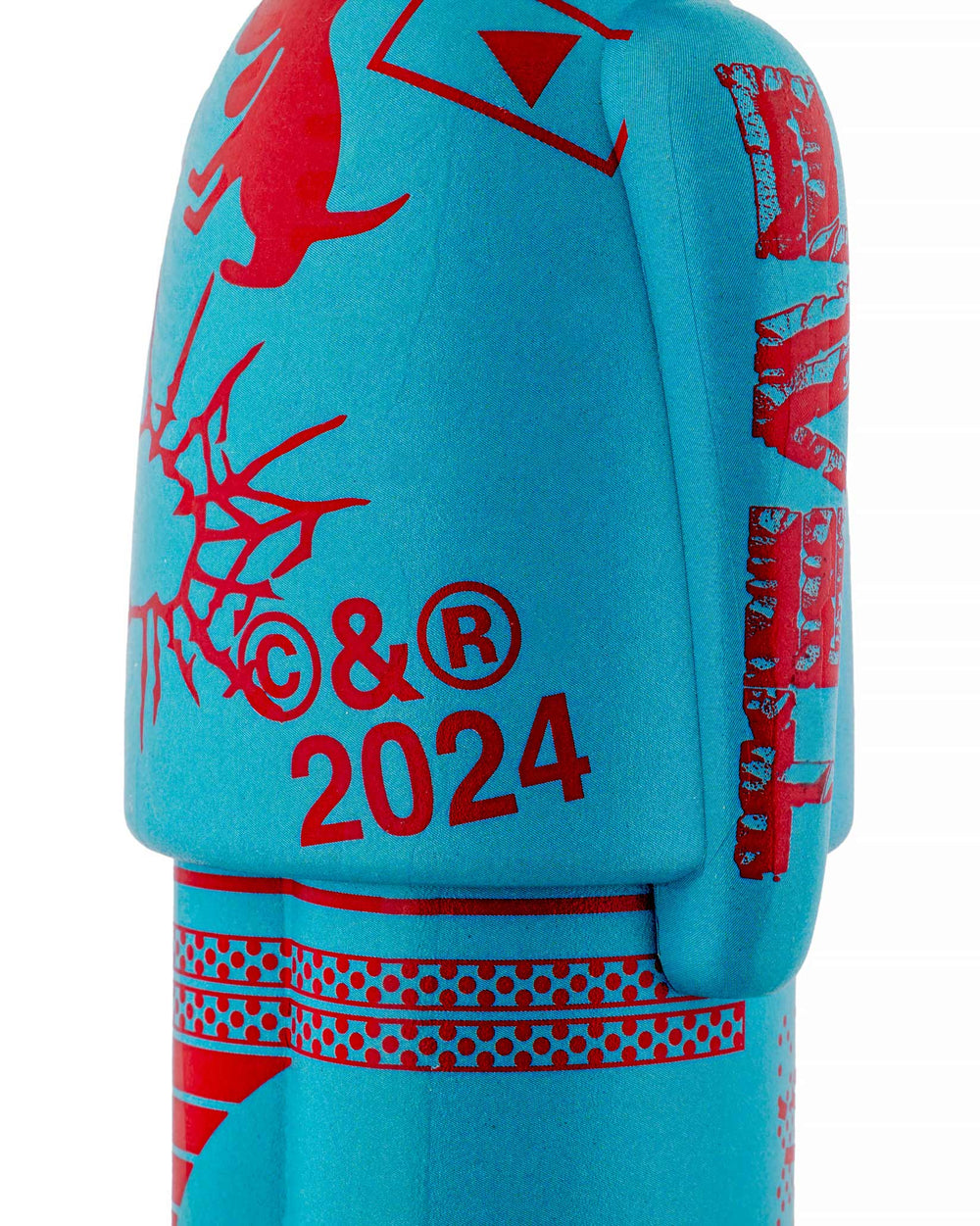 Turquoise human-shaped corkscrew by Alessi, detailed with red stylized creature, distressed graphics, '© & ® 2024' text, and polka dots.
