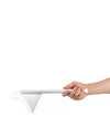 White lamp by Alessi, held by a hand, featuring a cylindrical handle and a triangular shade.