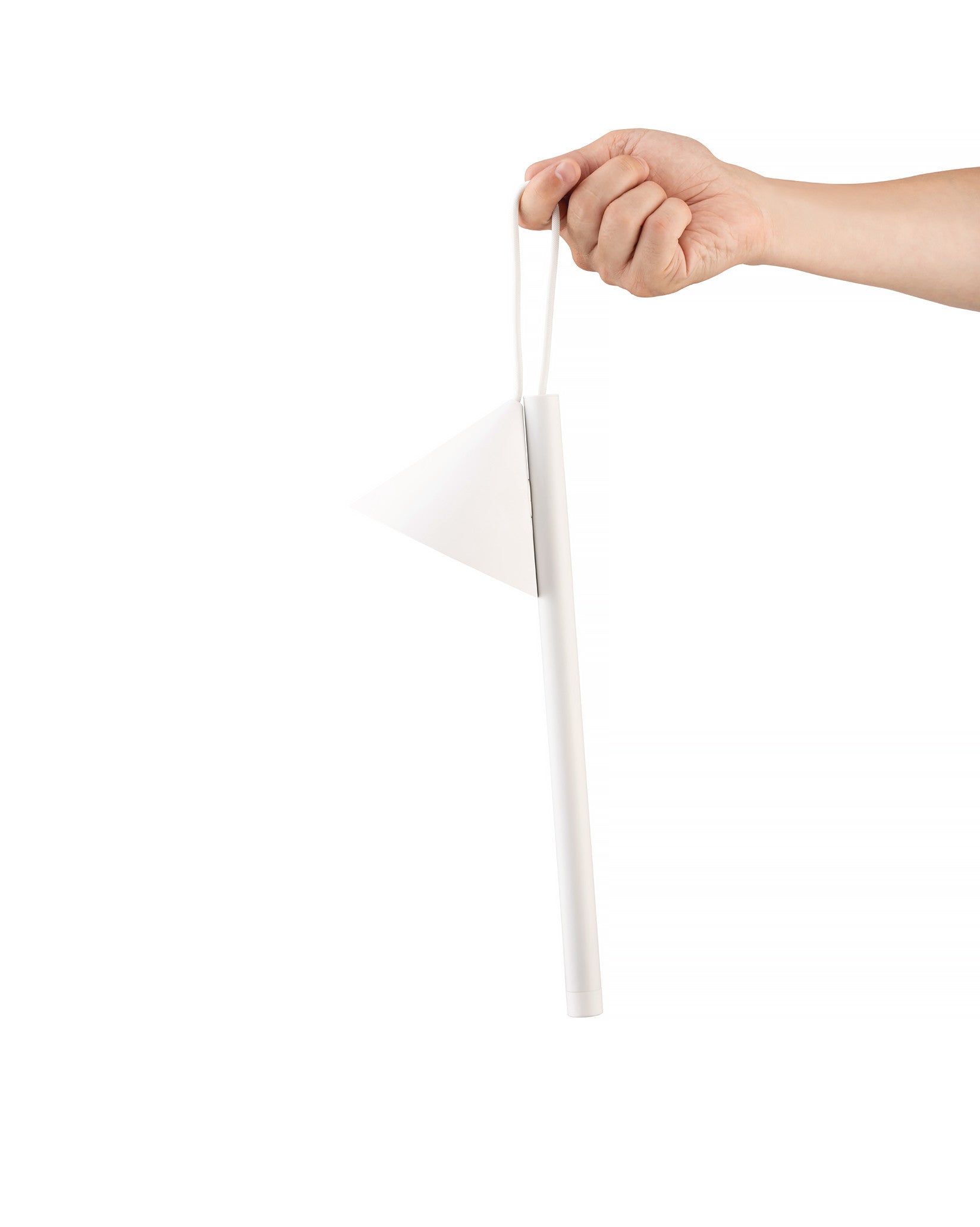 A white lamp by Alessi with a triangular shade and a cylindrical pole, held by a hand.