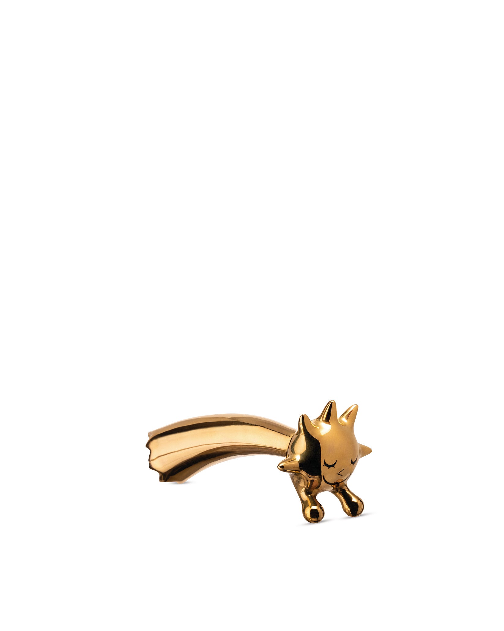 Polished golden Stella Stellina decorative figure by Alessi, a stylized sun with closed eyes and a flowing comet tail.