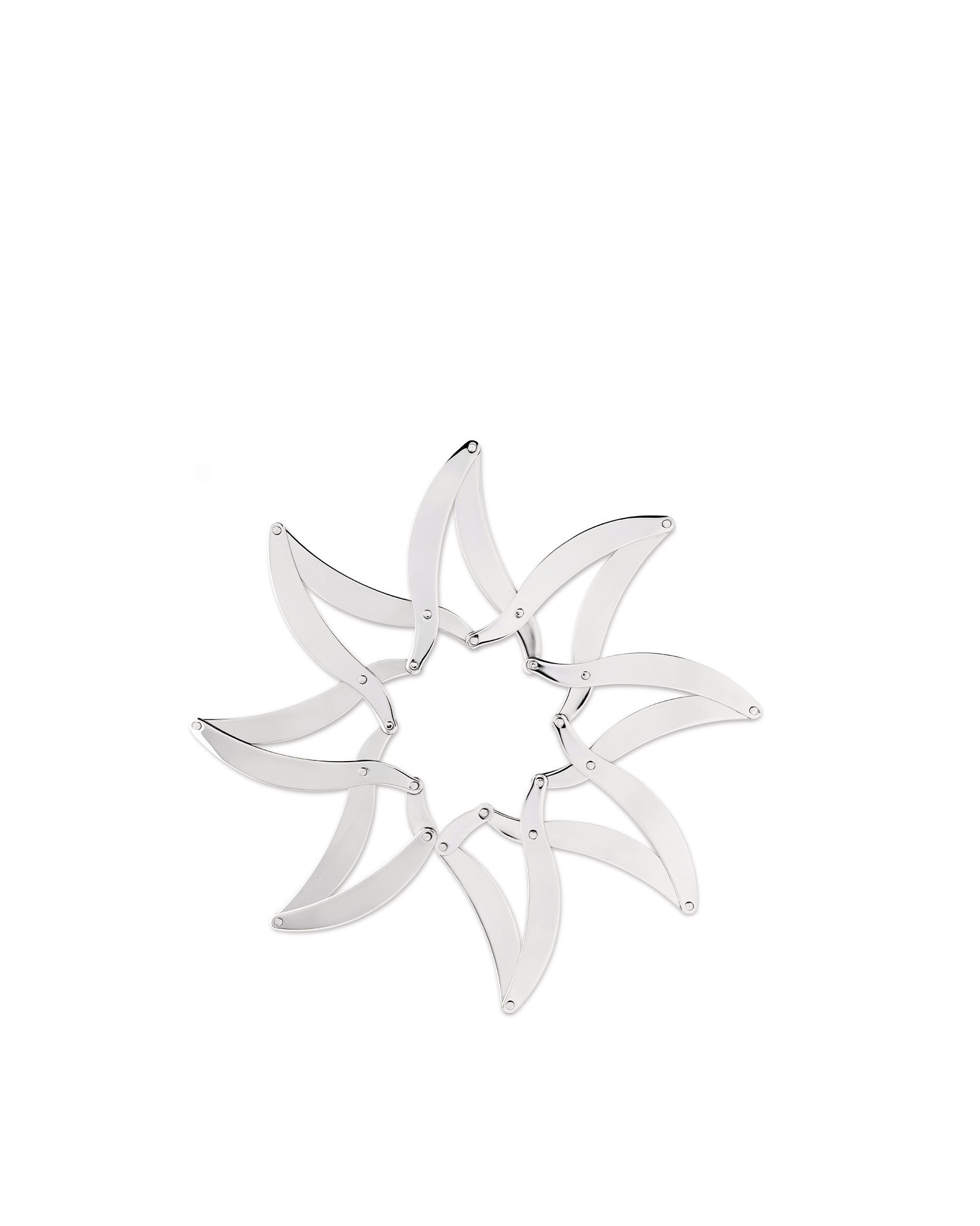 Silver metal trivet by Alessi, composed of multiple curved pieces interconnected in a star shape.