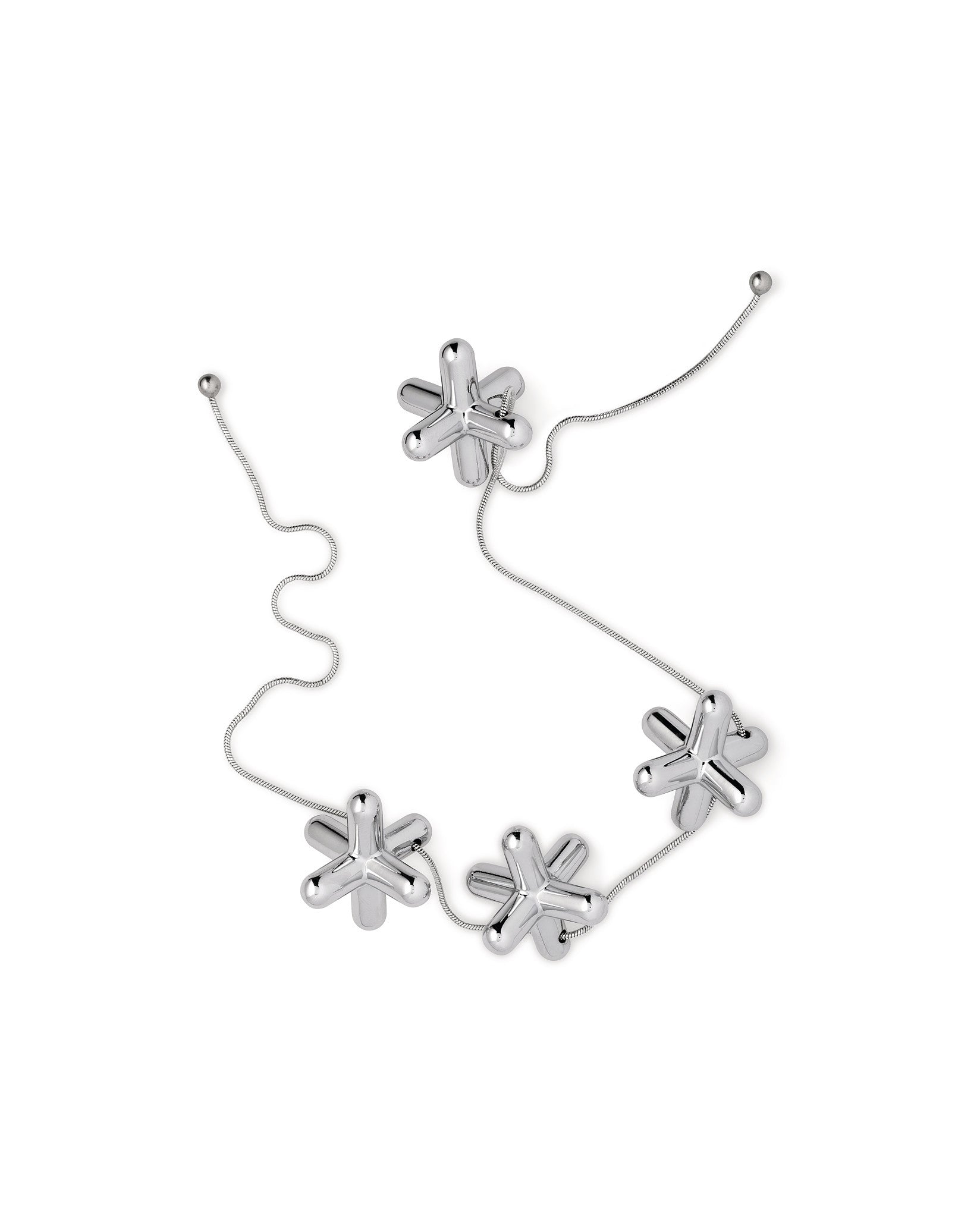 Tripod trivet by Alessi, composed of six reflective silver jack-like elements linked by a delicate chain.