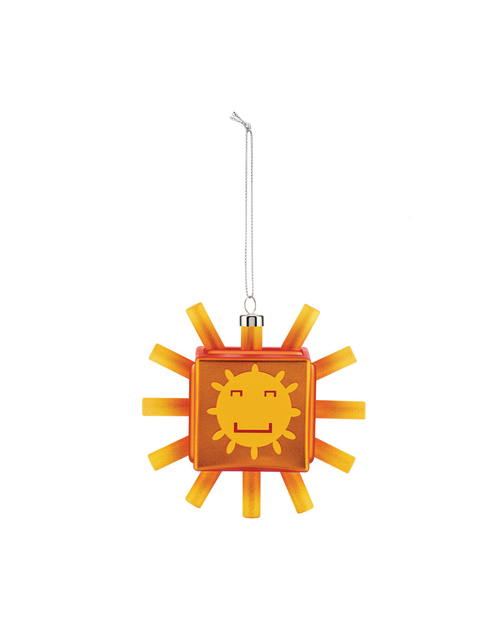 A translucent orange and yellow sunflake ornament by Alessi, with a smiling square face and radiating blocky rays, hanging from a silver chain.
