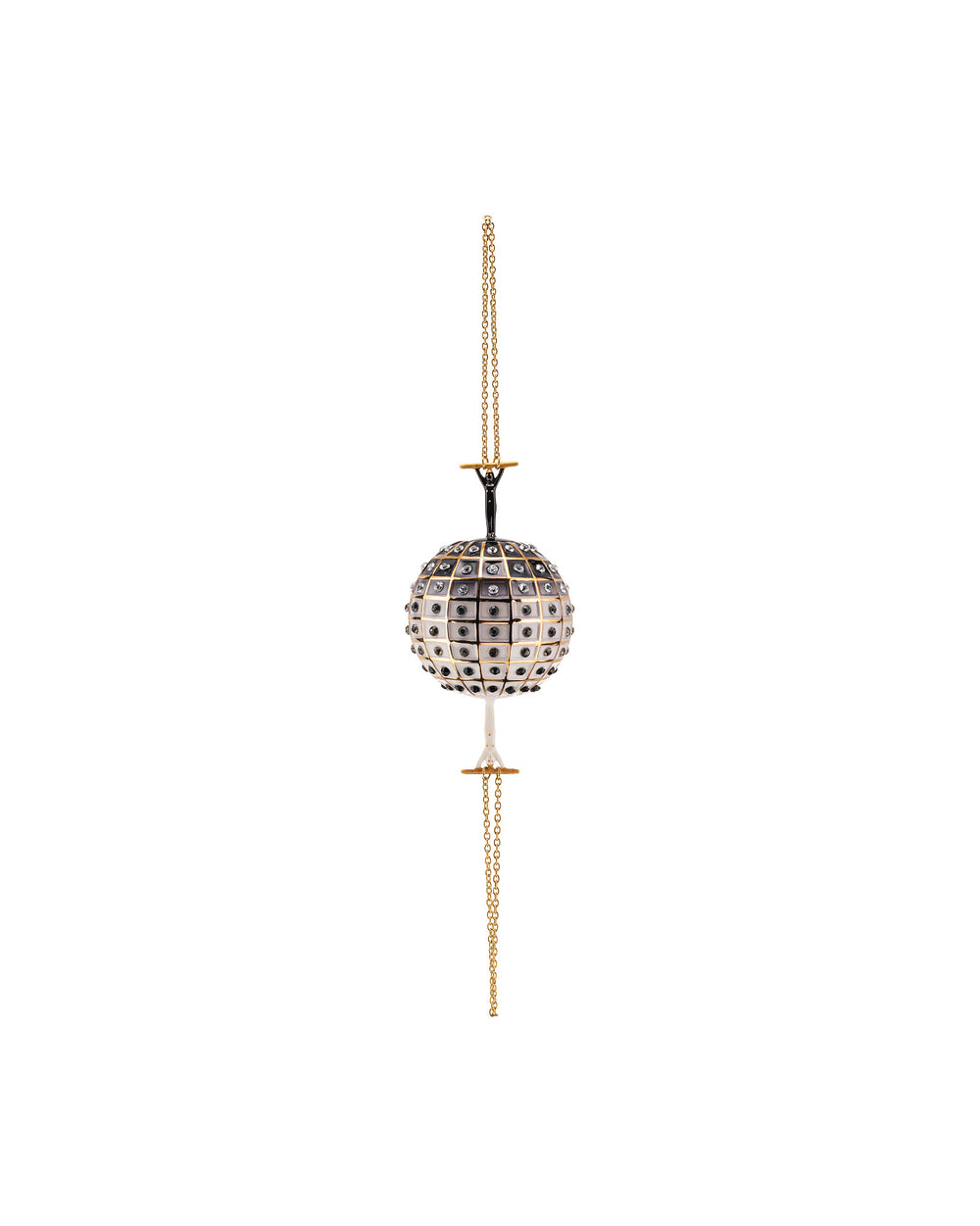 A spherical decorative ornament by Alessi, white and black checkerboard with clear rhinestones, held by black figures on a gold chain.