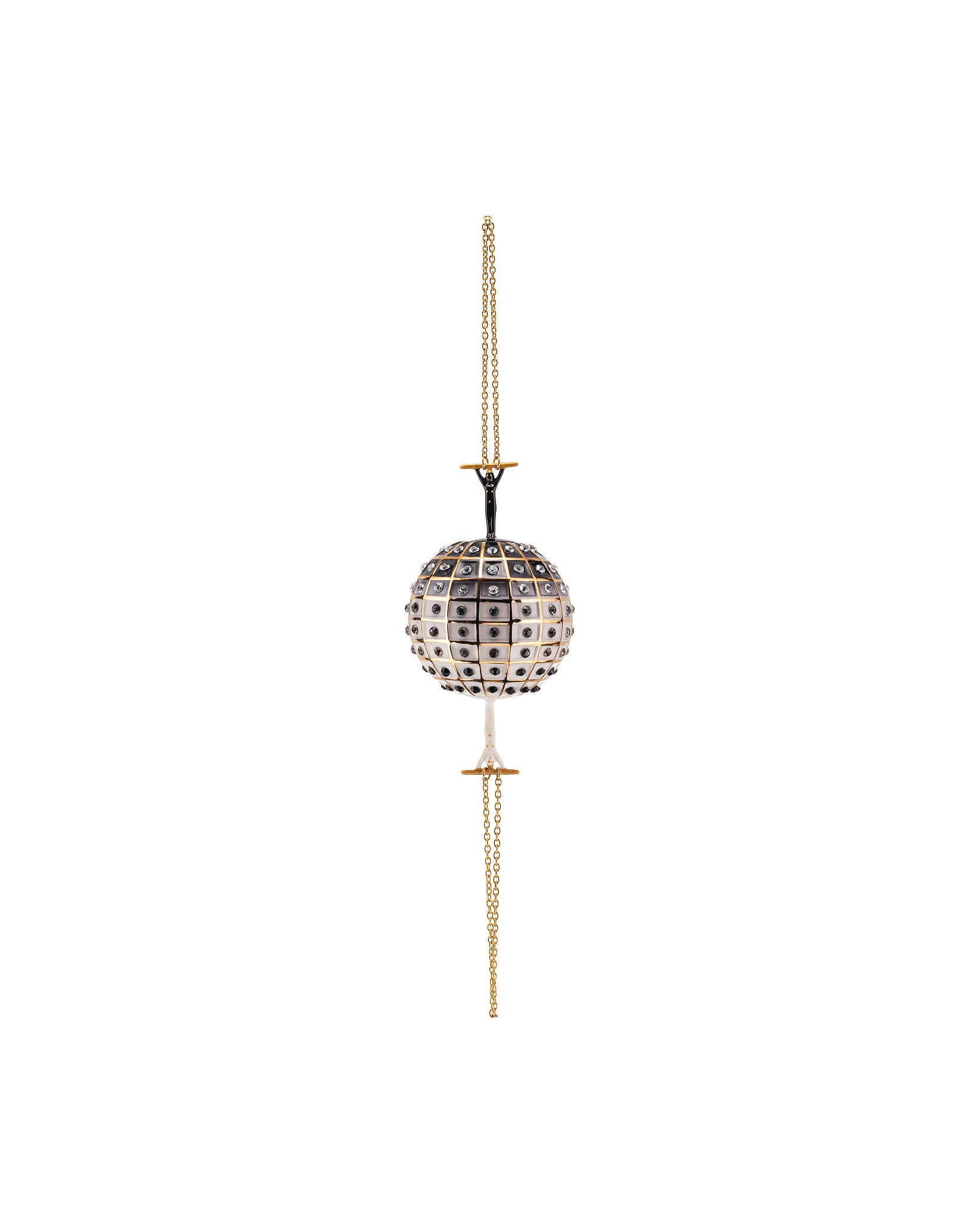 A spherical decorative ornament by Alessi, white and black checkerboard with clear rhinestones, held by black figures on a gold chain.