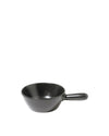 Small black serving pan by Alessi with a single handle and smooth finish, on a white background.