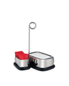 Stainless steel condiment caddy by Alessi with a black base, holding red sweetener packets and featuring a circular loop handle.