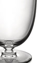 Clear glass by Alessi, with a visible stem and circular base, cropped on a white background.