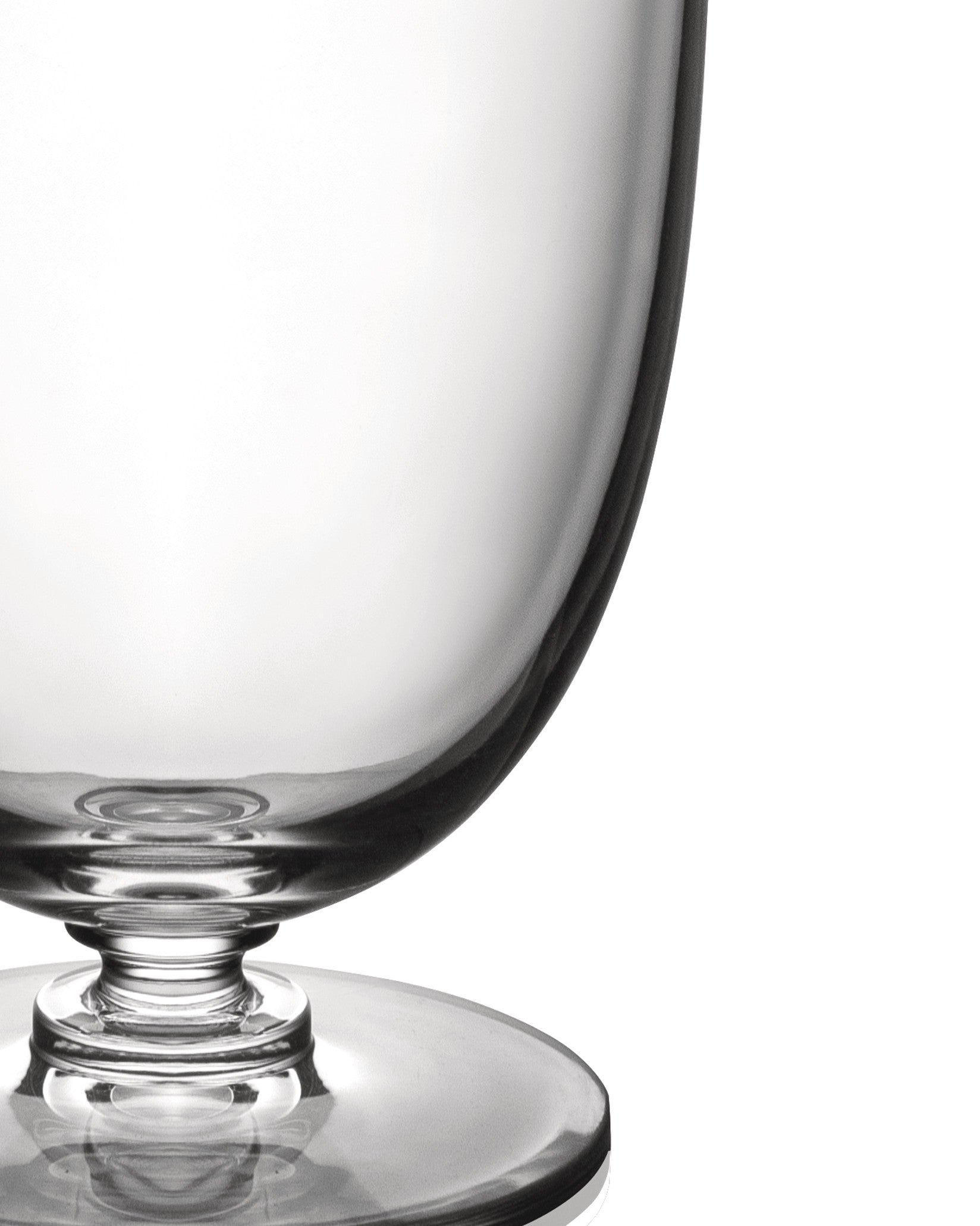 Clear glass by Alessi, with a visible stem and circular base, cropped on a white background.