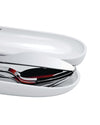 White portable food container by Alessi, partially open, revealing sleek chrome cutlery with red reflections.