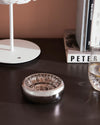 Polished silver-toned metal ashtray by Alessi featuring a distinct spiral wire design.