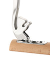 Polished chrome-plated metal nutcracker by Alessi with a squirrel-shaped top hinged to a light wooden base.
