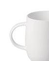 White ceramic mug by Alessi, a cropped side view showing the handle and smooth texture.