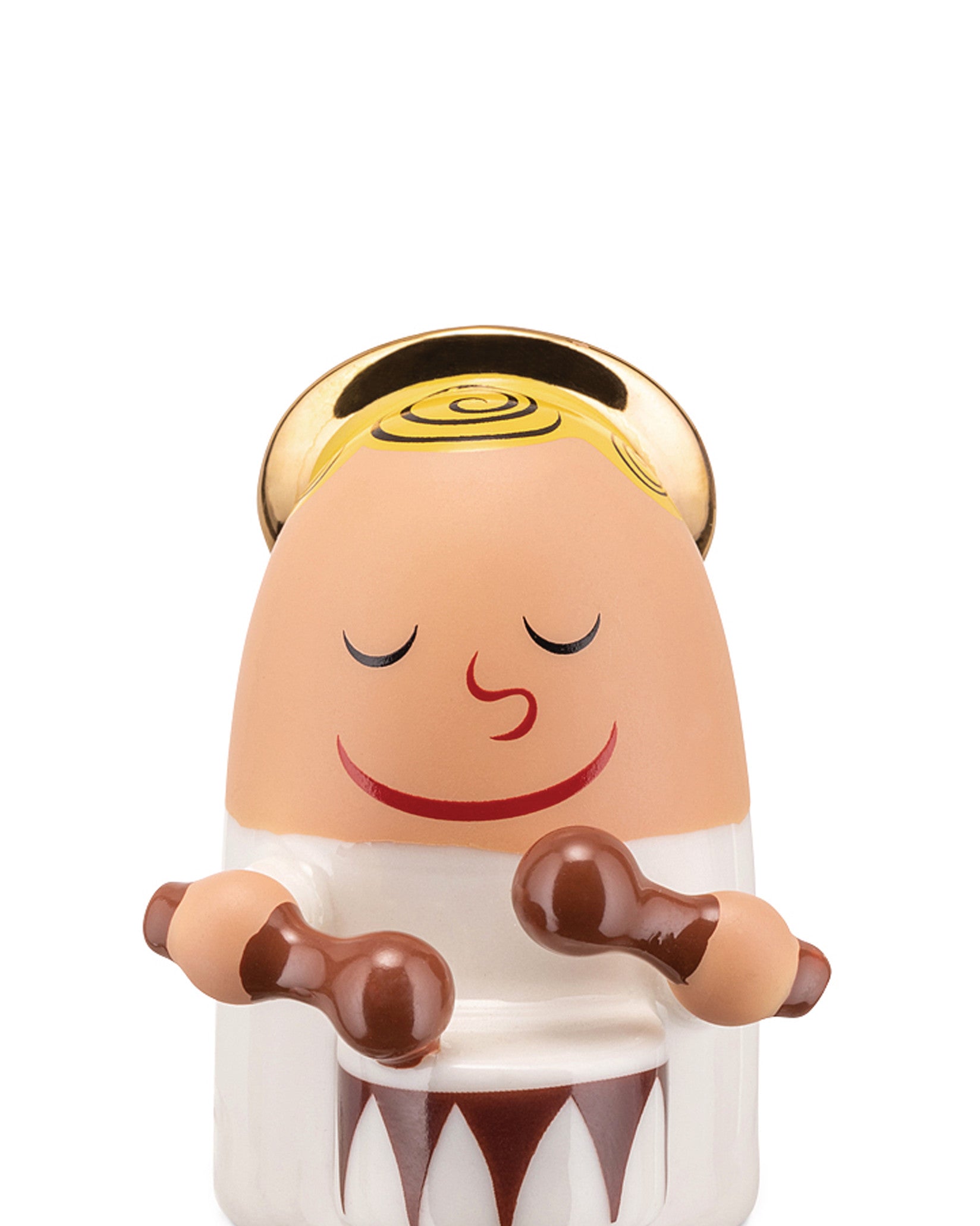 Light-toned angel figurine by Alessi with a golden spiral halo, closed eyes, smiling, playing a brown and white drum with mallets.