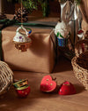 White swan ornament by Alessi, detailed with colorful accents and a golden base, hanging from a Christmas tree.