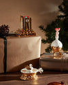 Gold jeweled architectural statuette by Alessi with colorful gems, displayed on a gift box.