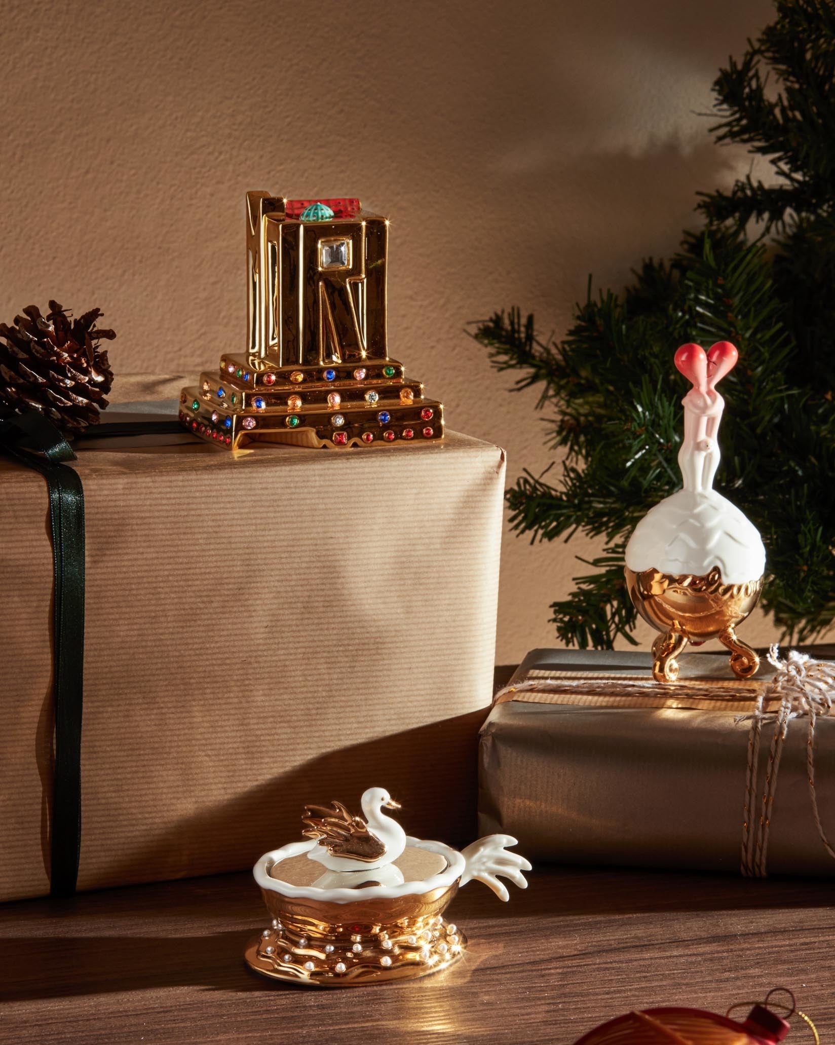 Gold jeweled architectural statuette by Alessi with colorful gems, displayed on a gift box.
