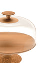 Wooden cake stand by Alessi with a clear glass cloche and an ornate carved base, close-up.