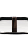 Dark brown textured cylindrical cookware knob by Alessi, standing on a reflective silver surface with a black rim.