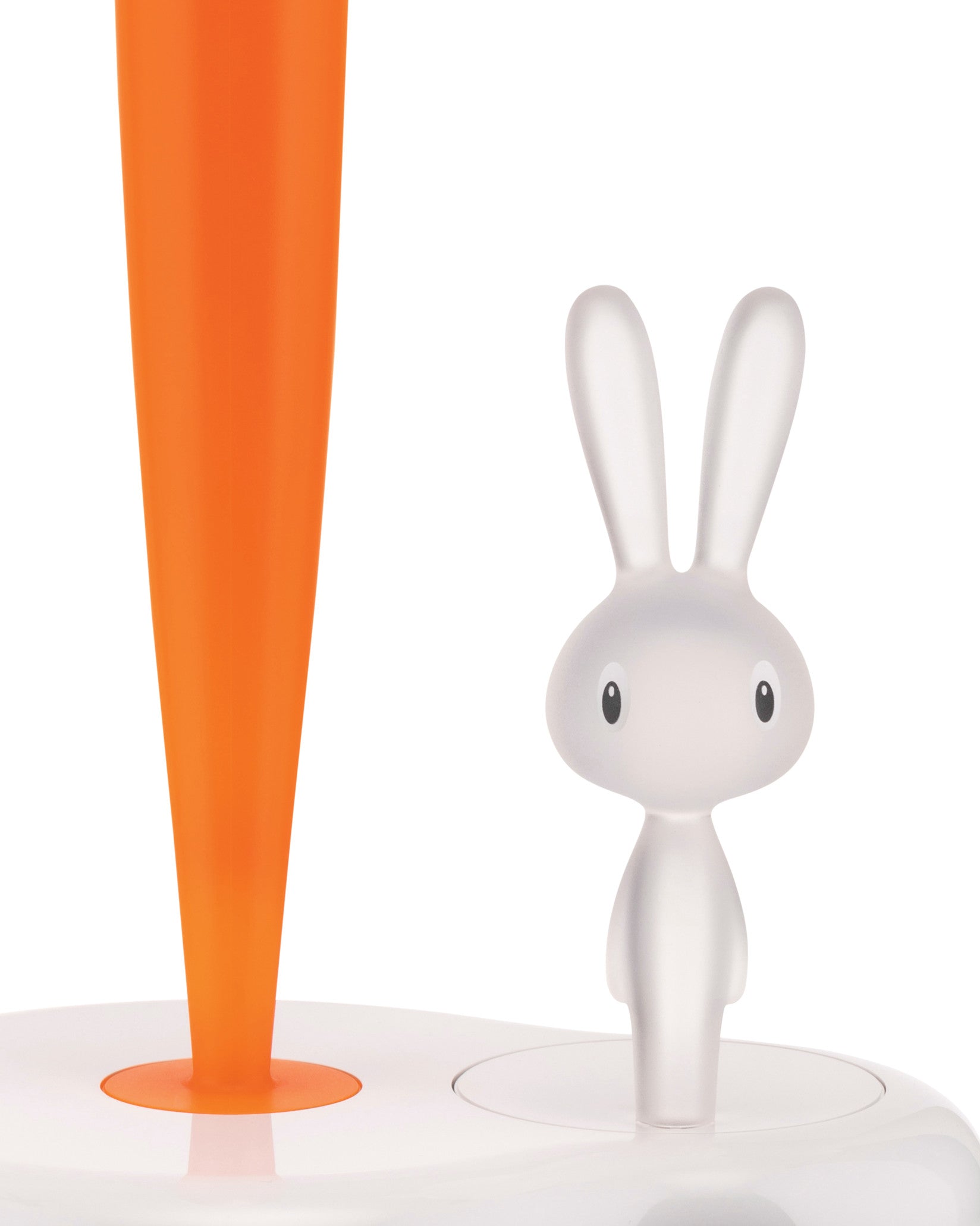 Bright orange carrot and frosted white bunny figurine by Alessi, both standing on a white base.