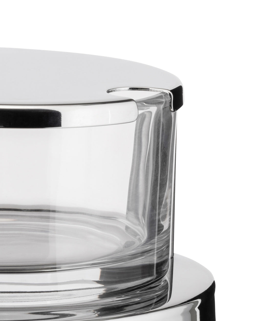 Chrome and glass cheese cellar by Alessi with a shiny reflective lid and clear container, cropped view.