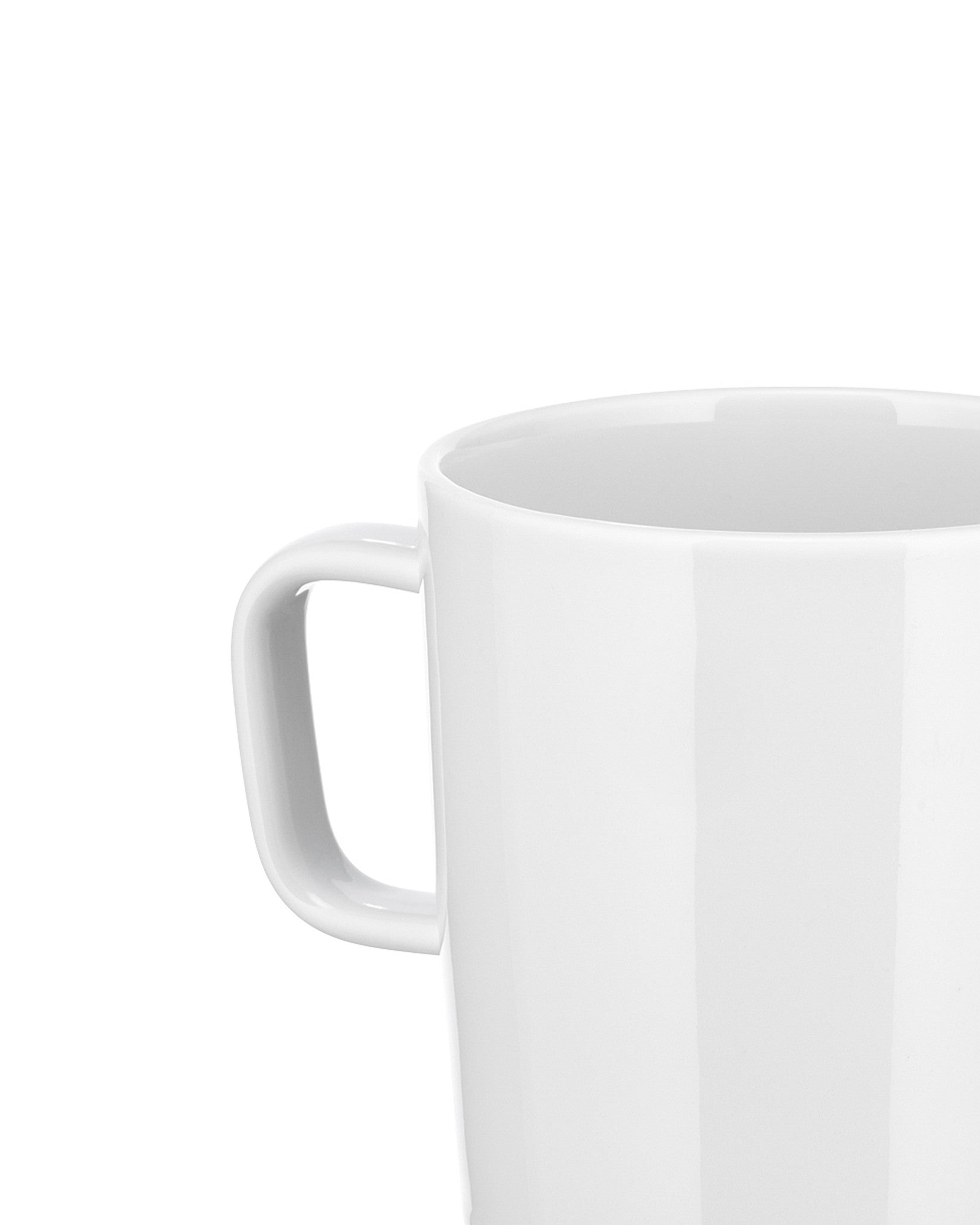 White ceramic mug by Alessi with a glossy finish and curved handle, cropped close-up.