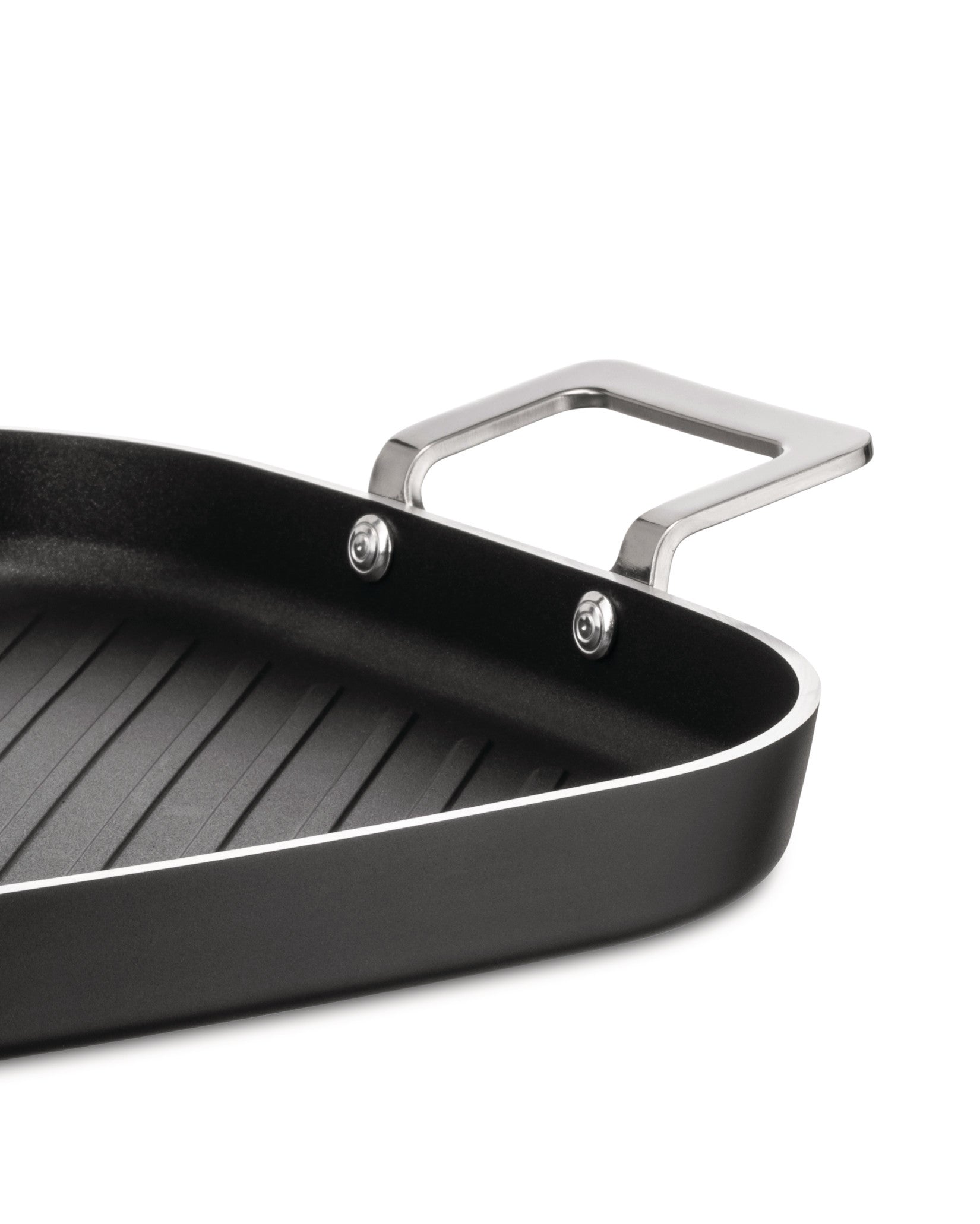 Black rectangular grill pan by Alessi with a ribbed cooking surface and shiny metal loop handles, cropped.
