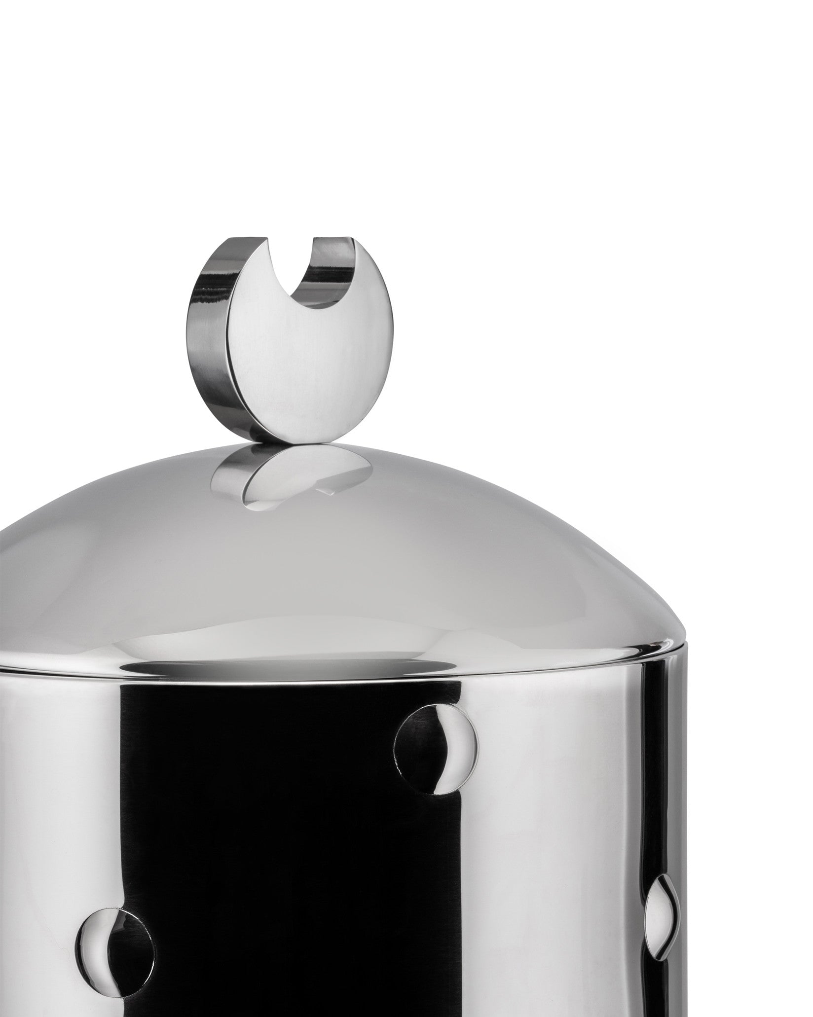Silver jar by Alessi with a crescent moon lid handle and moon-shaped side cutouts, cropped.