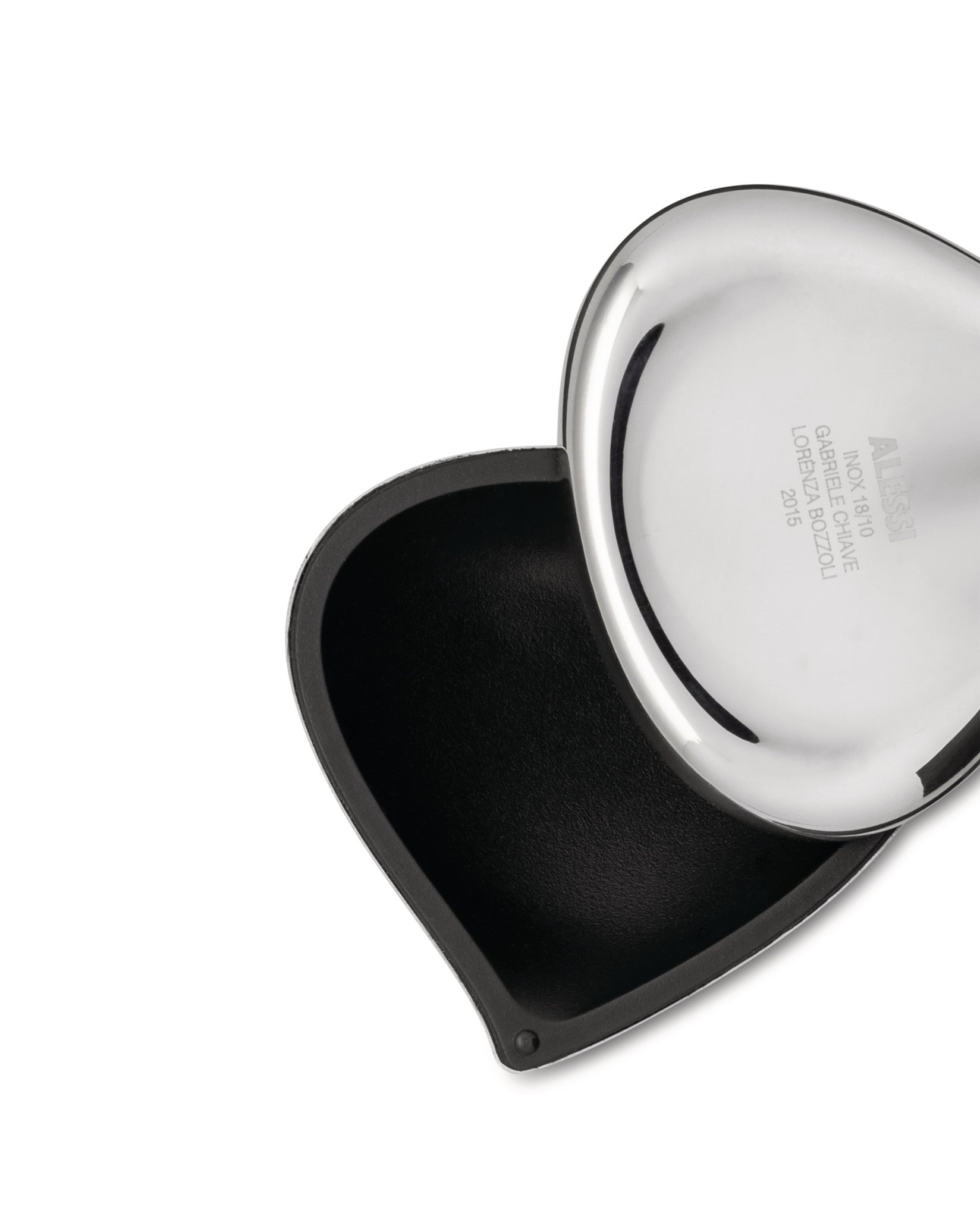 Polished stainless steel heart-shaped container by Alessi, open to reveal a black textured interior.