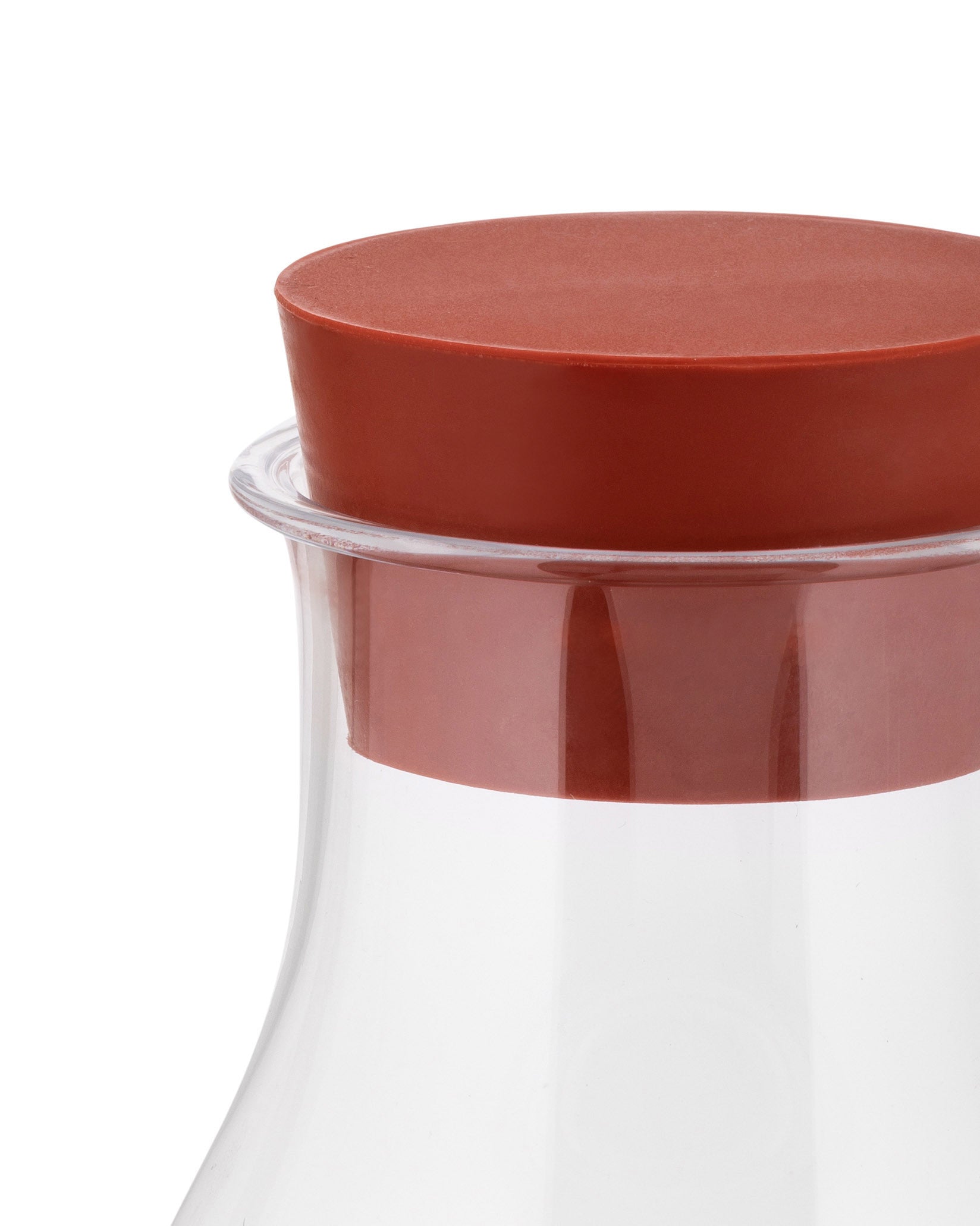 Clear glass Tonale Pitcher by Alessi with a rust-colored silicone stopper, shown in a close-up.