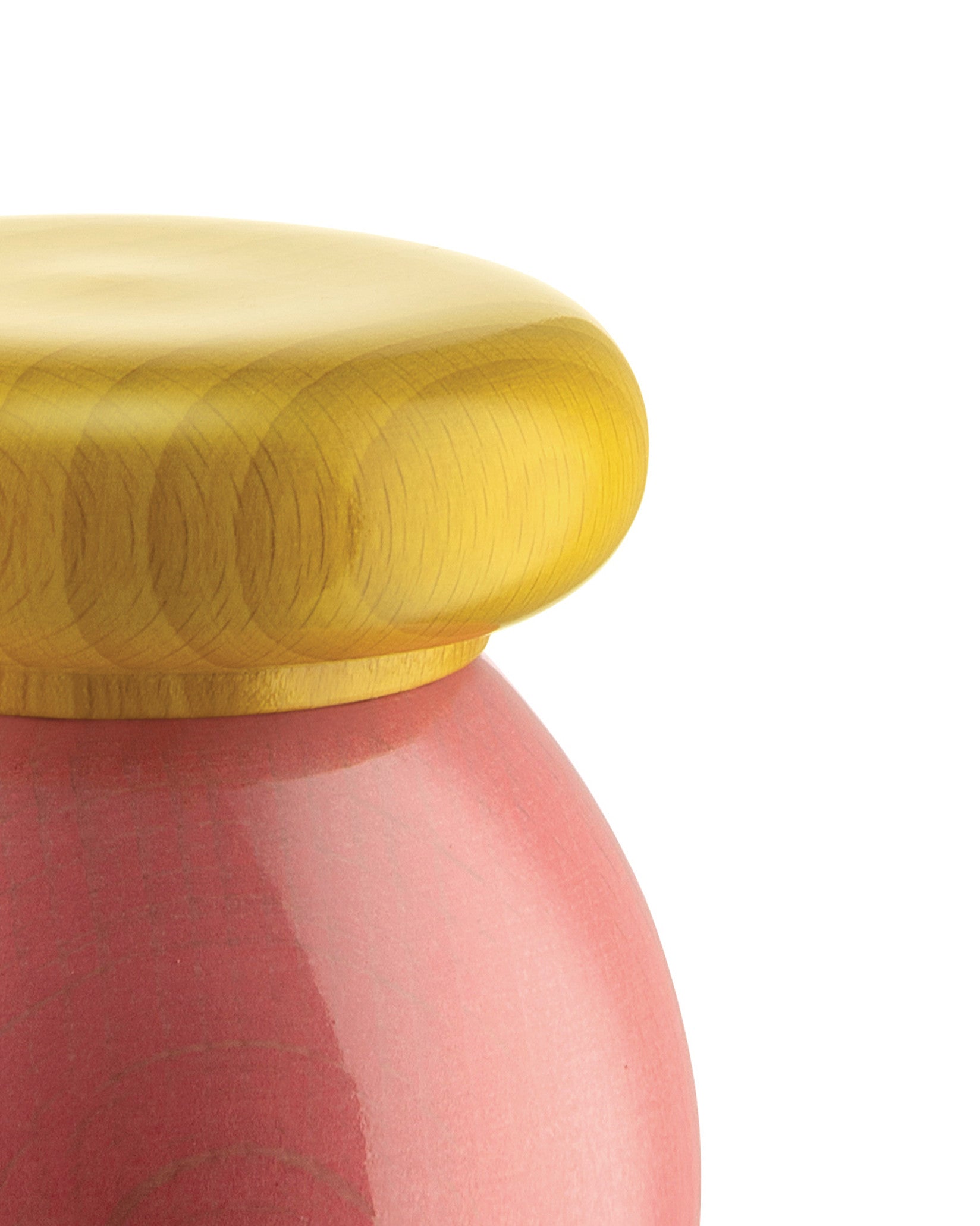 Golden lidded container with a pink base by Alessi, featuring a glossy finish and subtle concentric texture on the lid.