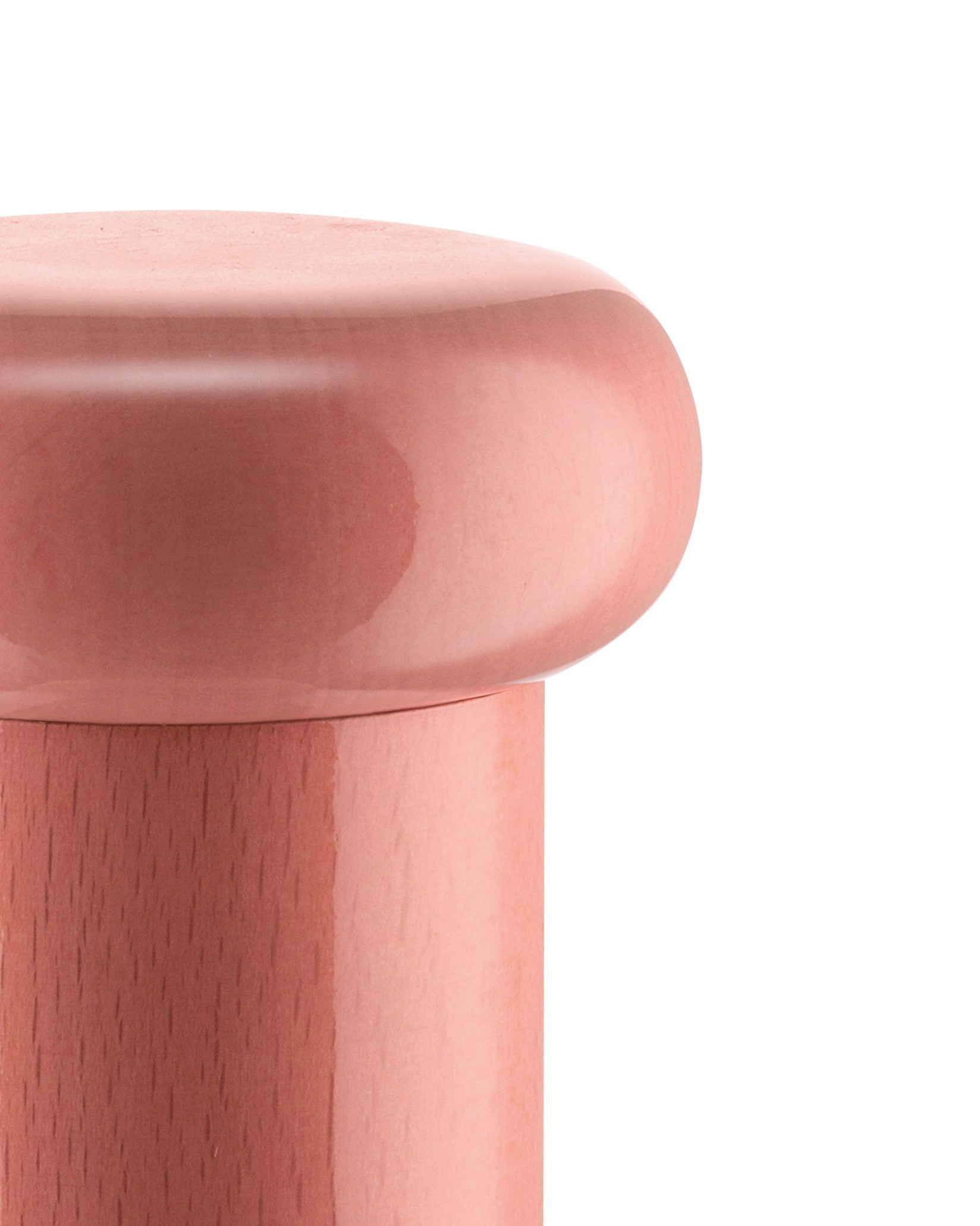 Pink kitchen mill by Alessi with a smooth, domed top and a contrasting pink wooden base, cropped view.