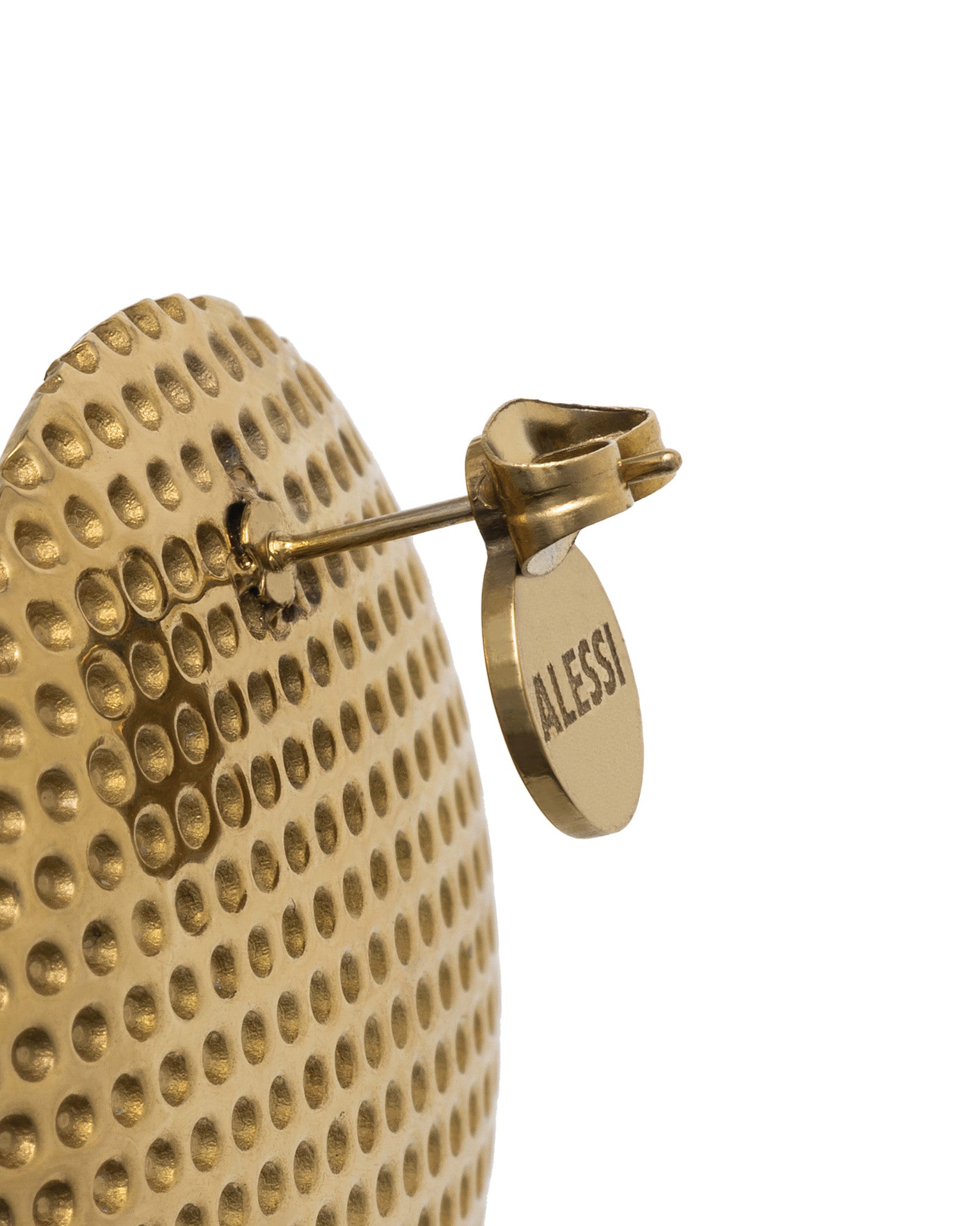 Gold-toned metal thimble by Alessi with dimpled texture and an engraved brand tag, close-up side view.